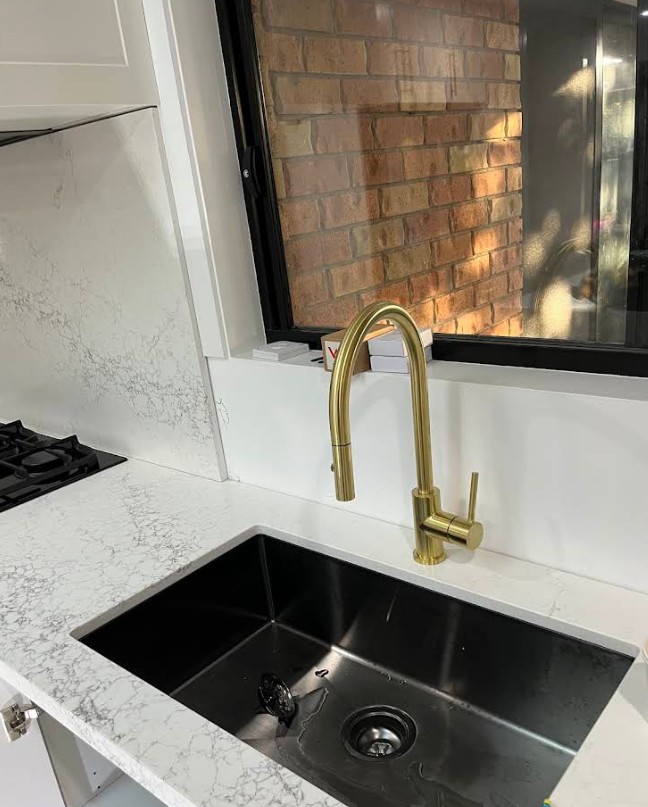 Kitchen sink with brushed gold tapware