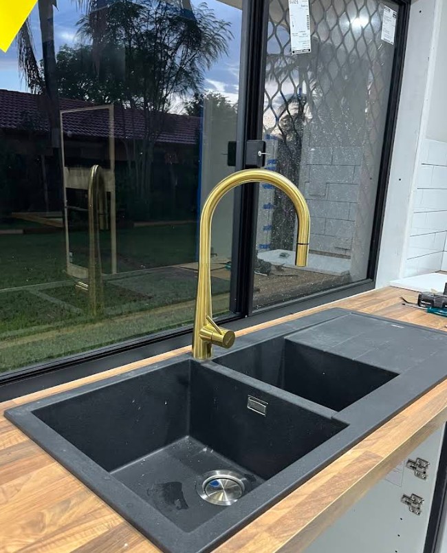 Modern black sink with gold tapware